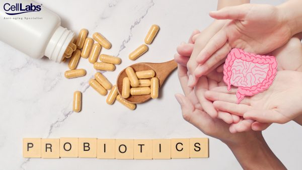 Image of a probiotics capsules, a scrabble spelling out the word "probiotics' and parents' hands cradling a stomach cutout with their child's.